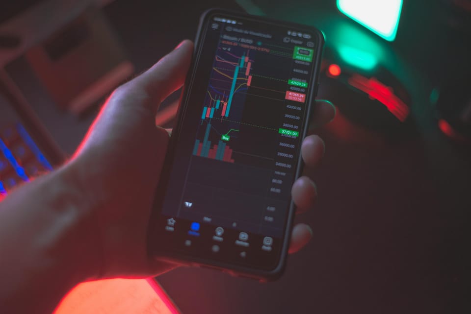 man holding his smartphone while looking at trading view trading platform chart showing a change of character